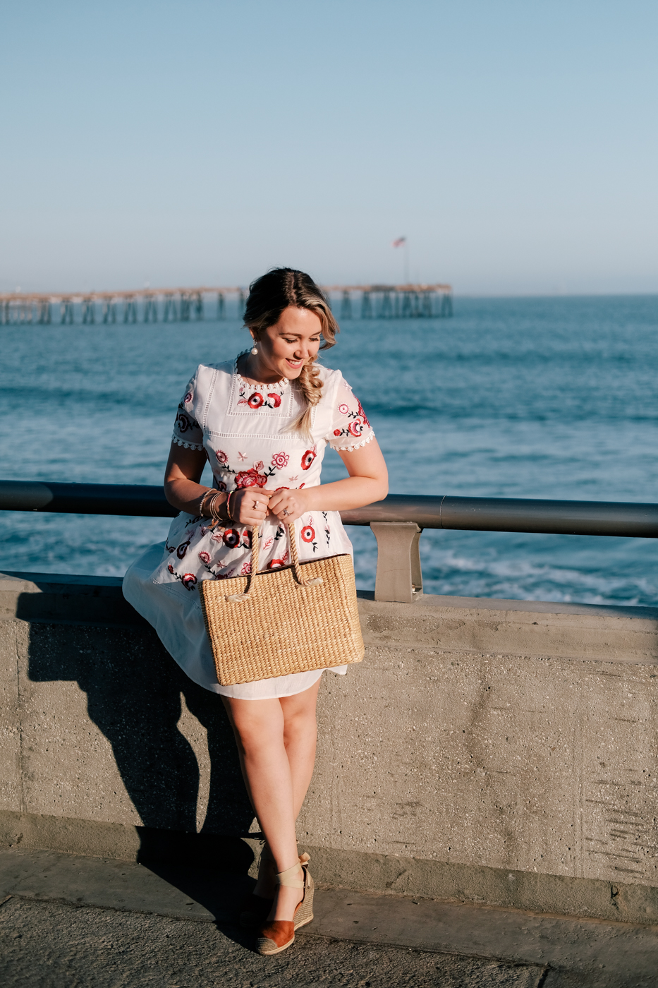 Debora Dahl, bolsa de palha e vestido branco bordado